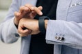 Unrecognizable male hands using smart watch. Businessman uses a smartwatch on his hand and keeps track of the time on Royalty Free Stock Photo