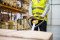 Male warehouse worker pulling a pallet truck. Royalty Free Stock Photo