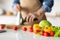 Unrecognizable Man In Apron Cooking Vegetable Meal In Kitchen