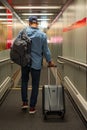 Man With Backpack And Suitcase Walking In Airport Terminal, Rear View Of Young Male On His Way To Flight Boarding Gate Royalty Free Stock Photo
