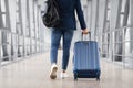 Unrecognizable Man With Bag And Suitcase Walking In Airport, Rear View Royalty Free Stock Photo