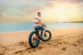 Unrecognizable man from behind looking at the sea riding a fat bike on the beach Royalty Free Stock Photo