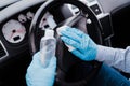 Unrecognizable man in a car using alcohol gel to disinfect steering wheel during pandemic coronavirus covid-19 Royalty Free Stock Photo
