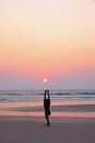 An unrecognizable man doing a yoga position sun salutation on an empty beach at sunset Royalty Free Stock Photo