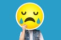 Unrecognizable man hiding his face behind crying sad emoticon emoji Royalty Free Stock Photo