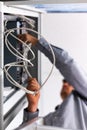 Unrecognizable man installs and connects the Internet cable to the fuse box.