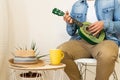 Unrecognizable man playing on a green ukulele in a modern studio Royalty Free Stock Photo