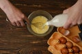 Unrecognizable man pouring milk into a bowl with eggs Royalty Free Stock Photo
