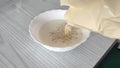 Unrecognizable man pours oatmeal into milk Royalty Free Stock Photo