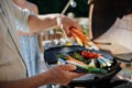 Unrecognizable man preparing vegetables for grilling during family summer garden party, close-up Royalty Free Stock Photo