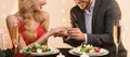 Unrecognizable Man Proposing To His Girlfriend In Restaurant, Putting On Ring