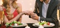 Unrecognizable Man Putting Ring On Girlfriend`s Hand During Dinner In Restaurant