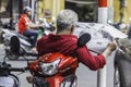 unrecognizable man in red shirt reads newspaper, sits on the sco Royalty Free Stock Photo