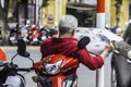 unrecognizable man in red shirt reads newspaper, sits on the sco