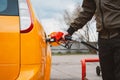 Unrecognizable man refueling car from gas station filling benzine gasoline fuel in car at gas station. Petrol high