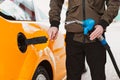 Unrecognizable man refueling car from gas station filling benzine gasoline fuel in car at gas station. Petrol high