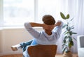 Unrecognizable man relaxing on chair at home with hands behind head Royalty Free Stock Photo