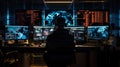 Unrecognizable man sitting against computer monitors in dark room of hacker base.