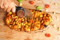 Unrecognizable man slicing an Italian pizza. Traditional food from Palermo, Sicily, Italy. Ingredients Tomato sauce, anchovy, Royalty Free Stock Photo