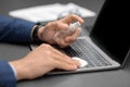 Unrecognizable man in suit cleaning laptop keyboard Royalty Free Stock Photo