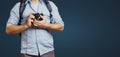 Unrecognizable Man Traveler Blogger Man With Backpack And Film Camera On Blue Background. Hiking Tourism Journey Concept