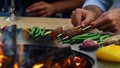 Unrecognizable man turning kebab outside. Unknown guy cooking meat on sticks Royalty Free Stock Photo