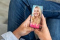 Unrecognizable man using smartphone and having video call with attractive lady girlfriend, sitting at home
