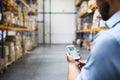 Man warehouse worker with a smartphone. Royalty Free Stock Photo
