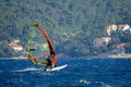 Unrecognizable man windsurfs past the idyllic Mediterranean coast in Croatia.