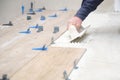 Unrecognizable mason putting tiles adhesive to the floor with a notched trowel. Royalty Free Stock Photo