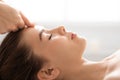 Unrecognizable masseuse massaging relaxed lady forehead, closeup Royalty Free Stock Photo