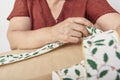 Unknown mature woman wrapping a Christmas gift, putting a decorative ribbon Royalty Free Stock Photo