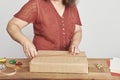 Unrecognizable mature woman tying a Christmas gift with a decorative cord Royalty Free Stock Photo