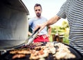 Unrecognizable man cooking seafood on a barbecue grill in the backyard. Close up. Royalty Free Stock Photo