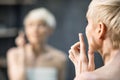 Unrecognizable Middle-Aged Woman Applying Anti-Aging Face Cream In Bathroom Royalty Free Stock Photo