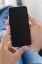 Unrecognizable millennial man check mail, social networks on smartphone with empty screen, at home