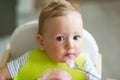 Unrecognizable mother feeding her baby daughter with yogurt