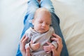 Unrecognizable mother with sleeping baby son sitting on bed Royalty Free Stock Photo