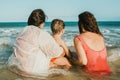 Unrecognizable mothers with son admiring waving sea in summer Royalty Free Stock Photo