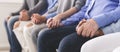 Unrecognizable people holding hands at group psychotherapy session
