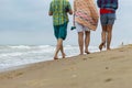 Unrecognizable people, three people are walking along the sea coast Royalty Free Stock Photo