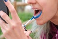 Unrecognizable person applying blue lipstick