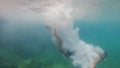 Unrecognizable person enters the water headfirst in slow-mo