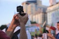 Unrecognizable person filming with an action camera during a protest