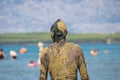 Unrecognizable person in healthy mud on beach