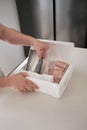 Unrecognizable person opening his weekly delivery of fish in an isothermal box.