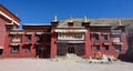 Unrecognizable person sits close to the entrance of beautiful Sakya monastery.