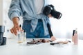 Unrecognizable Photographer Lady Putting Cosmetic Products On Table Indoor