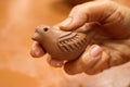 Unrecognizable potter master holding bird sculpture from clay clay in hand