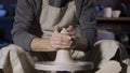 An unrecognizable potter sculpts soft clay with wet hands on a potter& x27;s wheel. Clay shaping and sculpting, close up